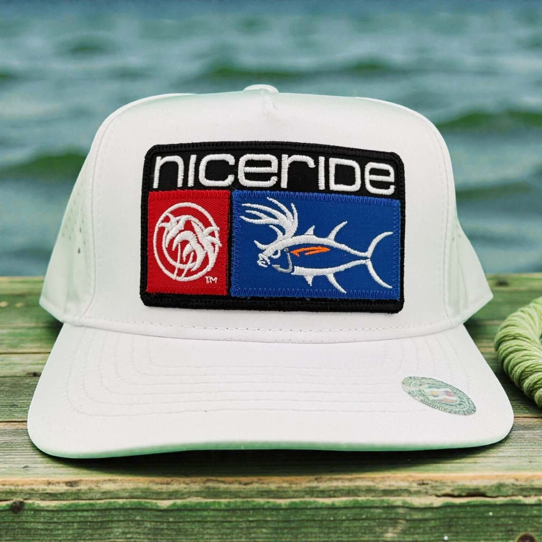 Shop NICERIDE embroidered cap with a unique fish design on a wooden deck by the water.
