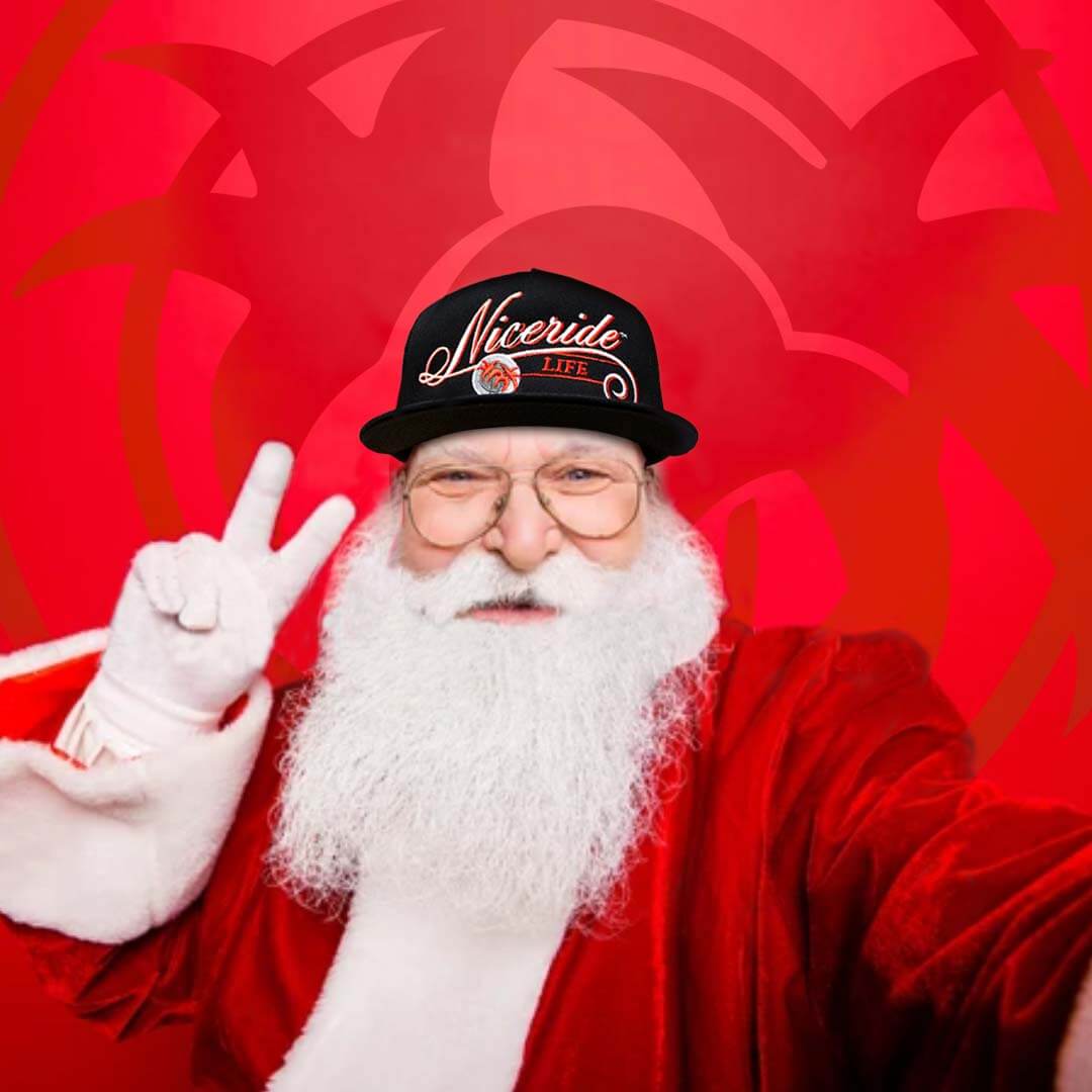 Santa Claus with a Niceride hat celebrating Christmas with a peace sign on a red background.
