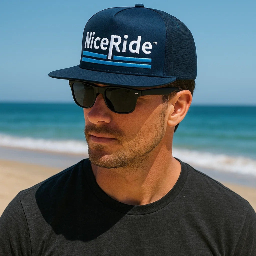 NiceRide Life snapback hat on a wooden table surrounded by flowers, perfect for stylish outdoor wear. Featuring Hat.