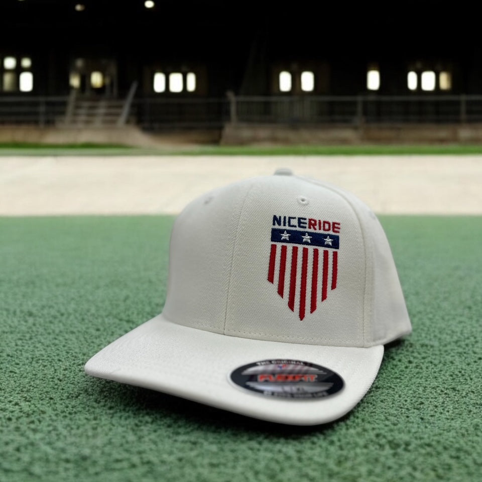 NICERIDE baseball cap featuring an embroidered logo on a gray background, set on green turf.