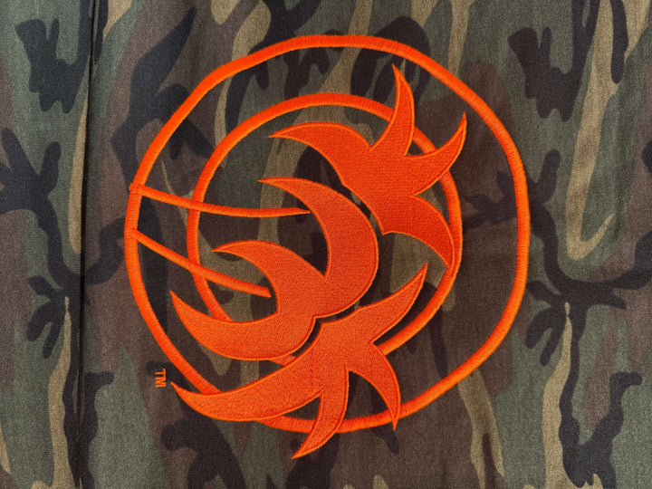 Close-up of Niceride Palm camouflage blanket with embroidered orange logo on fabric.