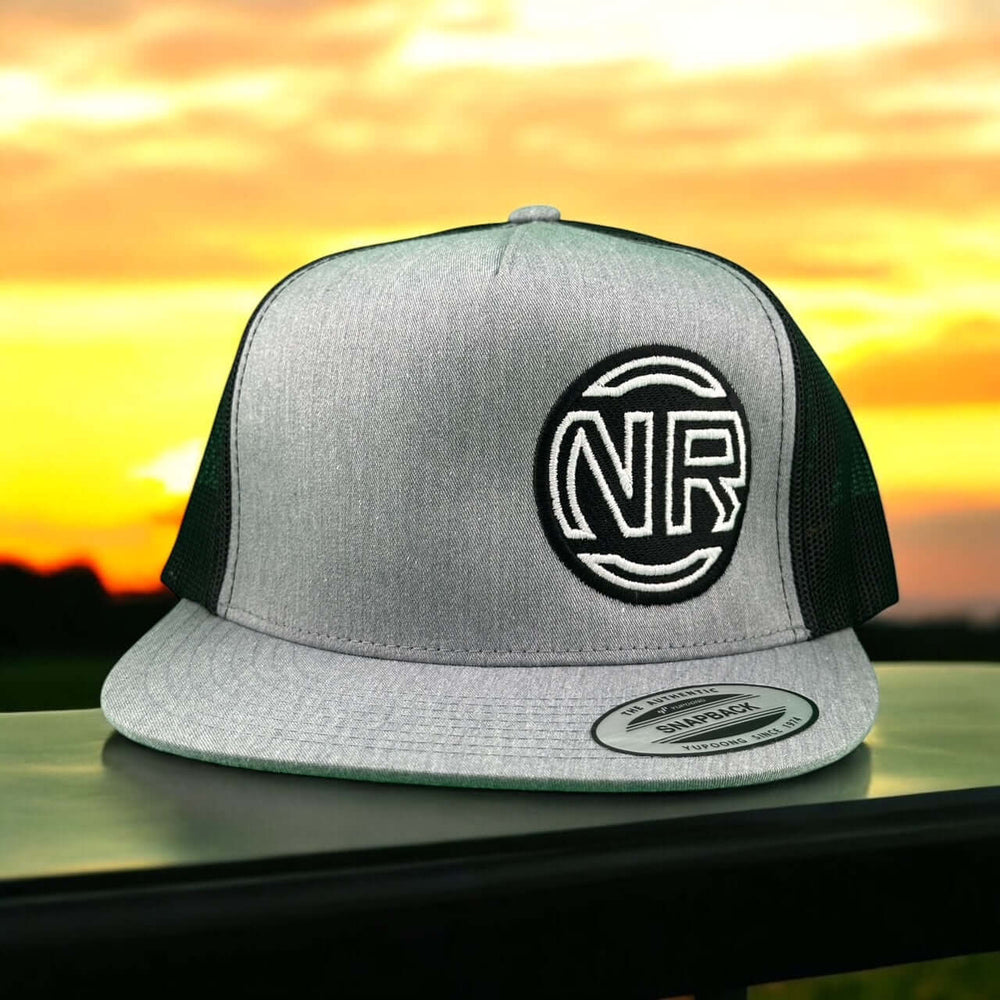 NICERIDE Inner Circle Trucker Hat in gray with NR logo, set against a colorful sunset.