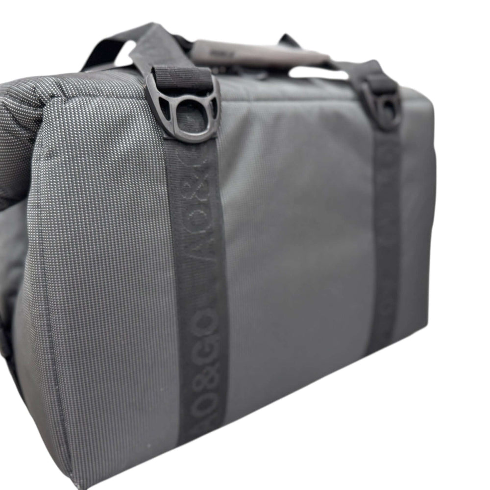 Side view of the MUD embroidered cooler, showcasing its durable gray fabric and sturdy straps.