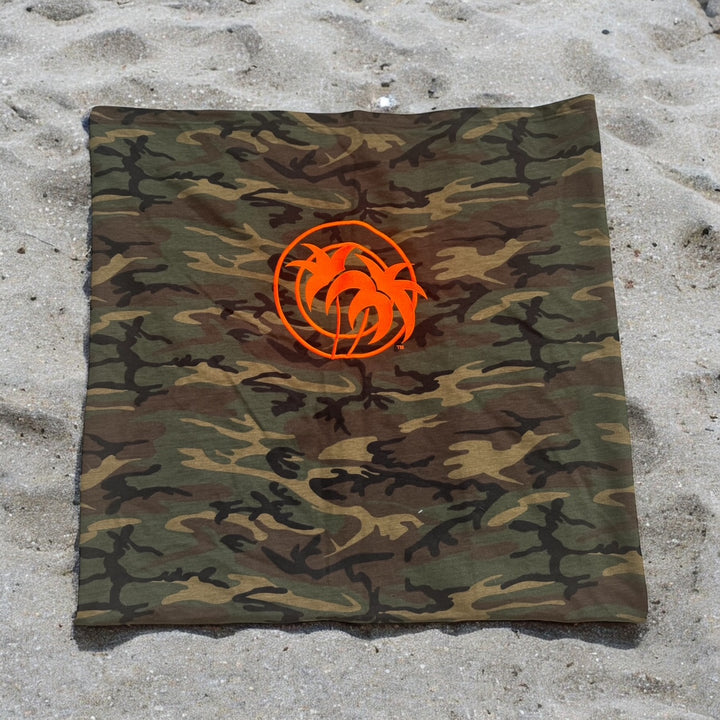 Niceride Palm camouflage fleece sweatshirt blanket with orange logo on sandy beach.