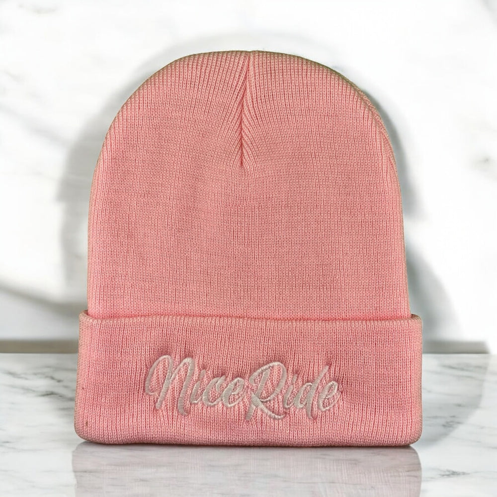 Pink unisex cuff beanie with NiceRide embroidered logo, made from soft acrylic for comfort and style.