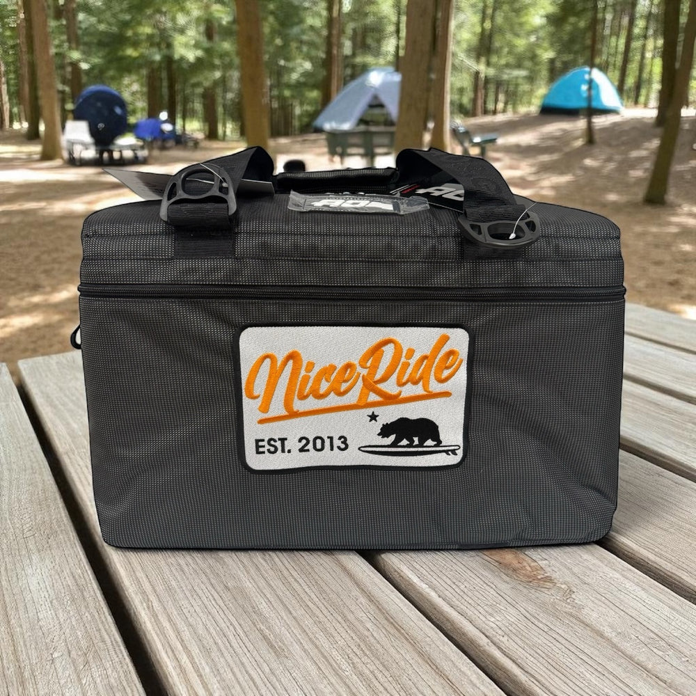 NICERIDE black vinyl soft-sided cooler with embroidered logo in campsite, 36-can capacity cooler.