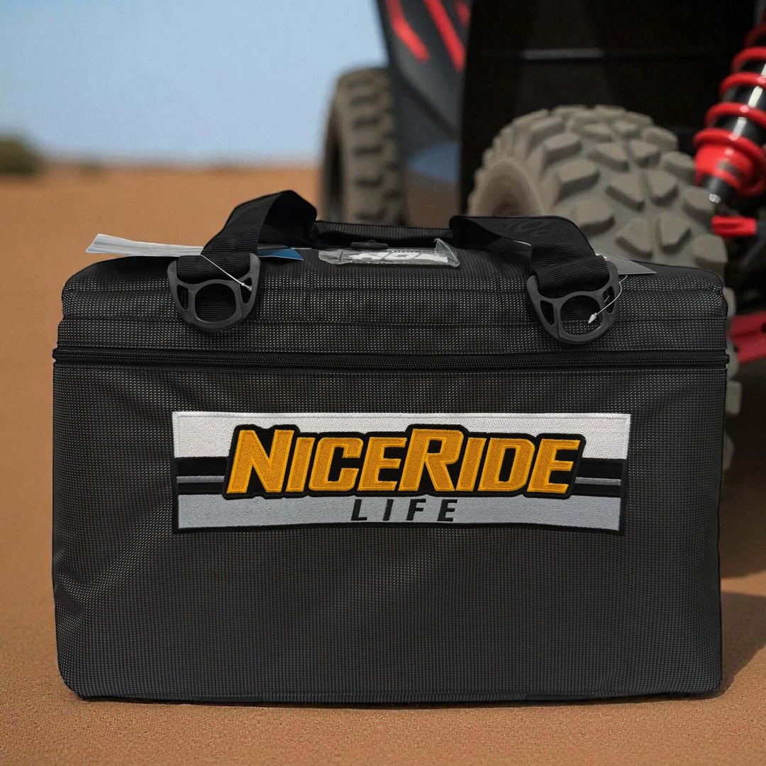 MUD embroidered cooler shown in black vinyl, featuring NICERIDE Life logo on the side in a rugged outdoor setting.
