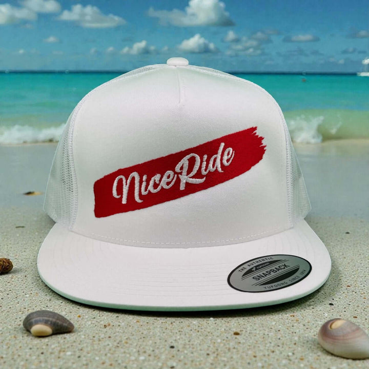 NICERIDE "Stripe" 6006 Unisex Adjustable Trucker Hat with logo on white background by the beach.