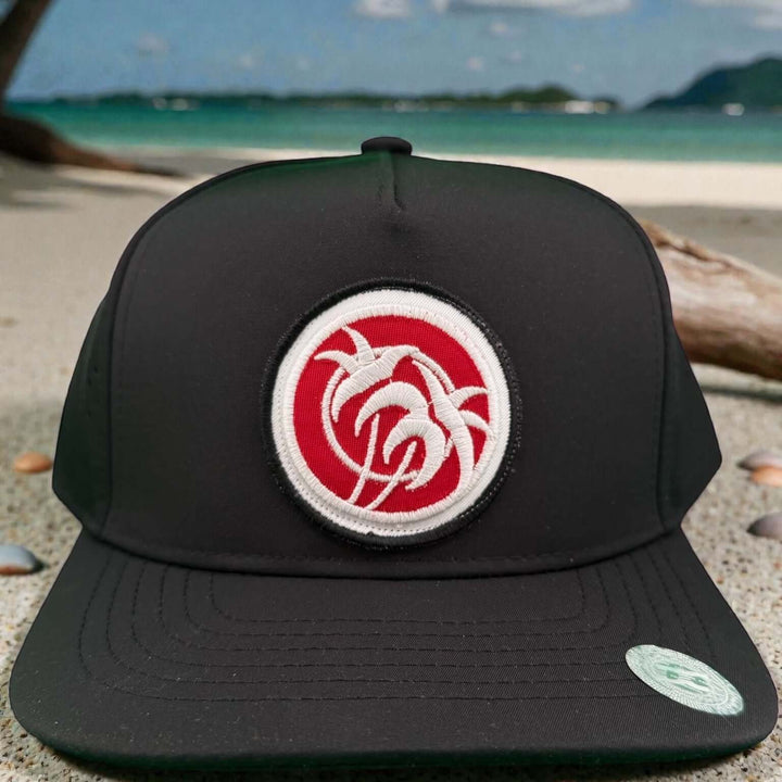 Rojo Negro 5-Panel Performance Golf Trucker Cap featuring palm tree embroidery on a black snapback.
