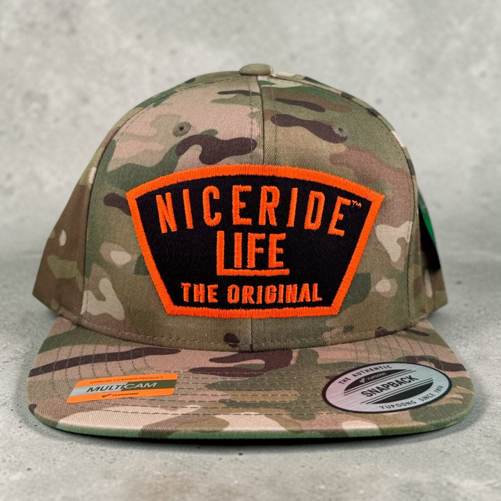 NICERIDE "GRINDER" hat with Multicam design and logo, unisex adjustable trucker cap on gray background.