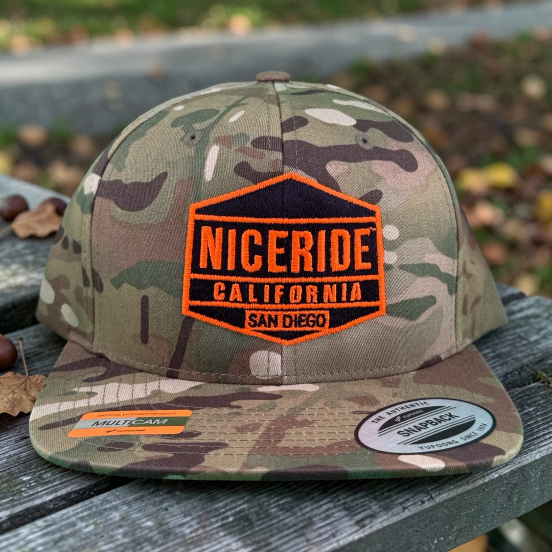 NICERIDE GOOD TIMES 6089 Unisex Adjustable Multicam Trucker Hat on a wooden surface.