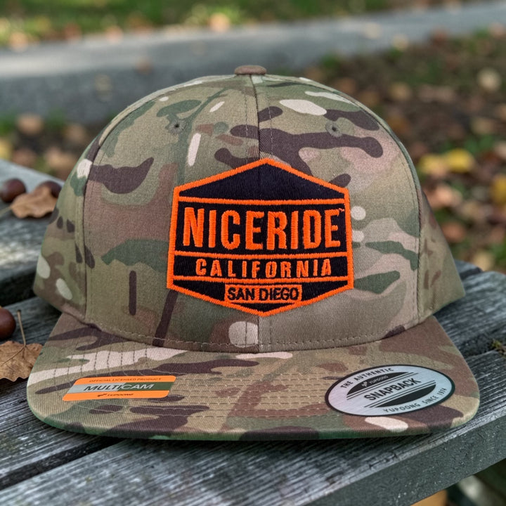 NICERIDE GOOD TIMES 6089 Unisex Adjustable Multicam Trucker Hat on a wooden surface.