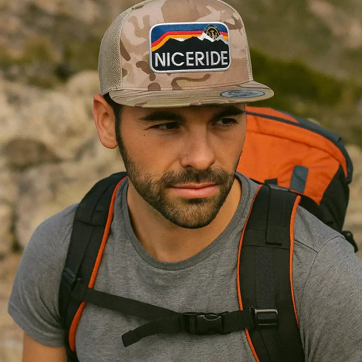 Glacier 6006 Unisex Tan camo Adjustable Trucker Hat worn by a man outdoors with a backpack.