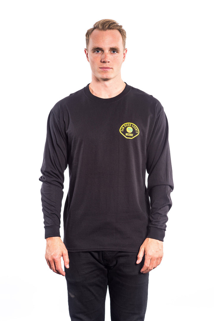 Model wearing The Badge Hanes pre-shrunk 100% cotton long sleeve shirt with logo on left chest