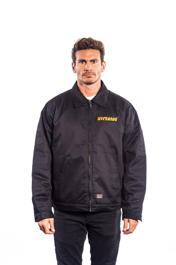 Man wearing a NICERIDE embroidered jacket, showcasing its canvas material and zip-up design.