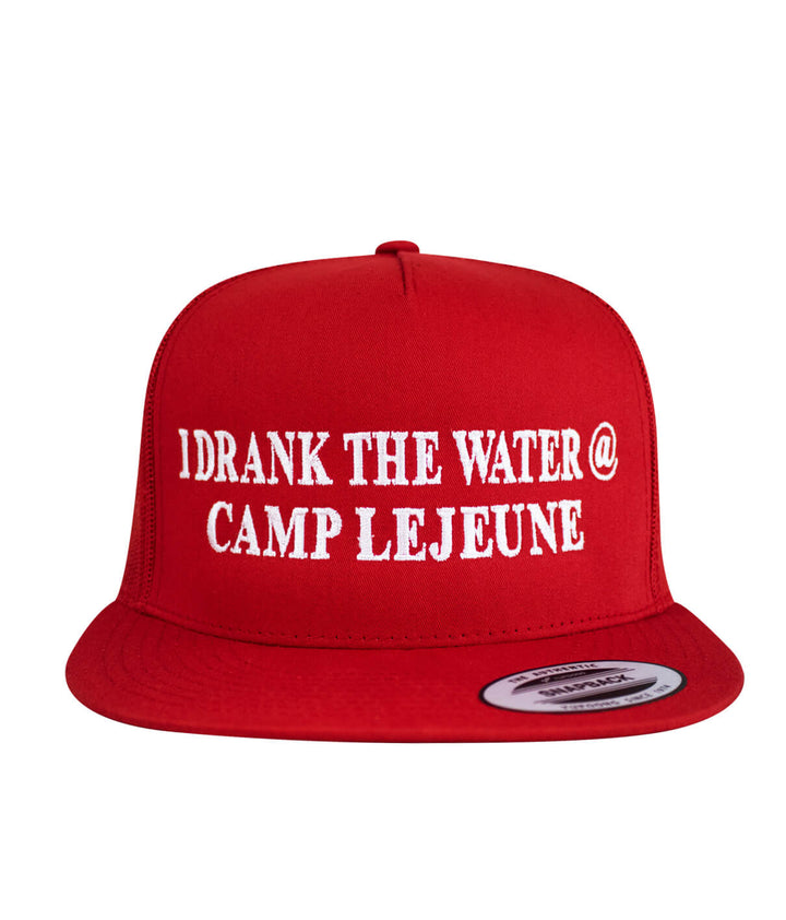 I Drank the Water @ Camp Lejeune trucker hat in red with white embroidered text on the front.