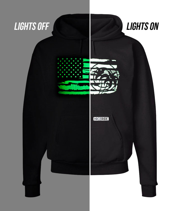 Strong Faded black pullover hoodie with glowing American flag design, showing lights off and lights on effects.