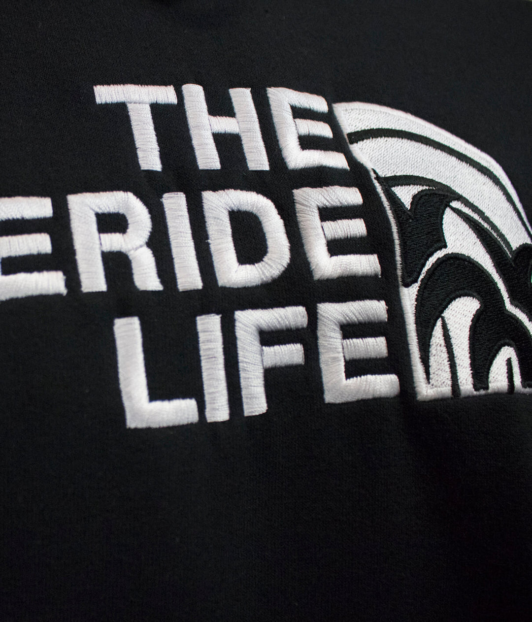 Close-up of the embroidered "THE NICERIDE LIFE" text on a black hoodie, showcasing quality design details.