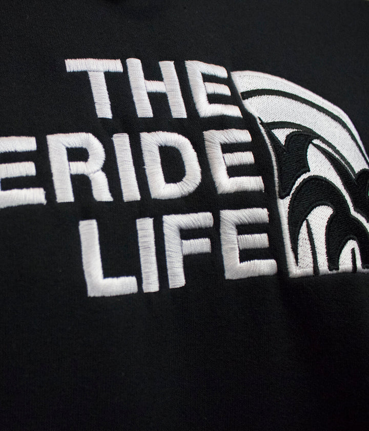 Close-up of the embroidered "THE NICERIDE LIFE" text on a black hoodie, showcasing quality design details.