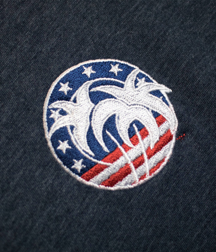 Embroidered Spirit of 76 logo on a navy t-shirt showcasing red, white, and blue design with stars.