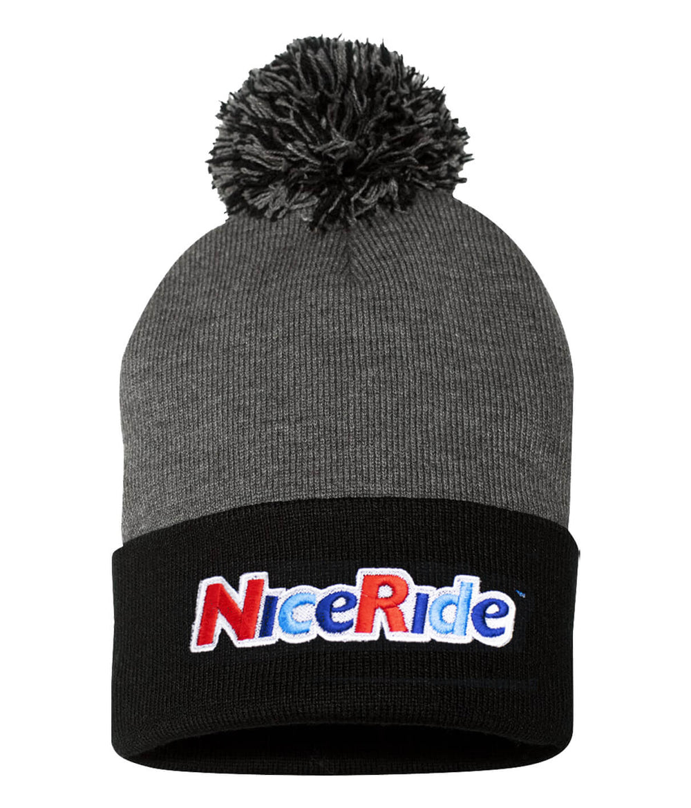 NICERIDE Smile Puff Beanie with pom-pom, featuring a black cuff and cheerful logo, perfect for warmth and style.