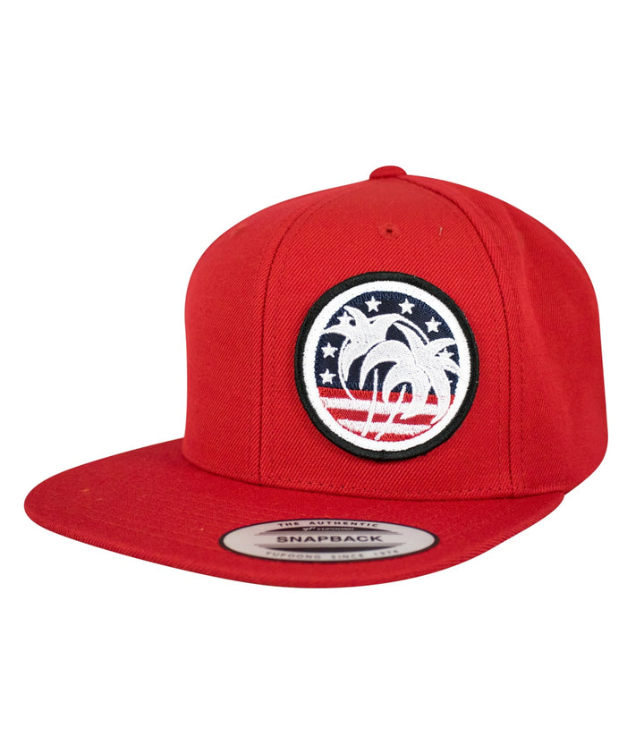 Embroidered red flatbill snapback hat featuring a palm tree design and Americana stars and stripes motif.