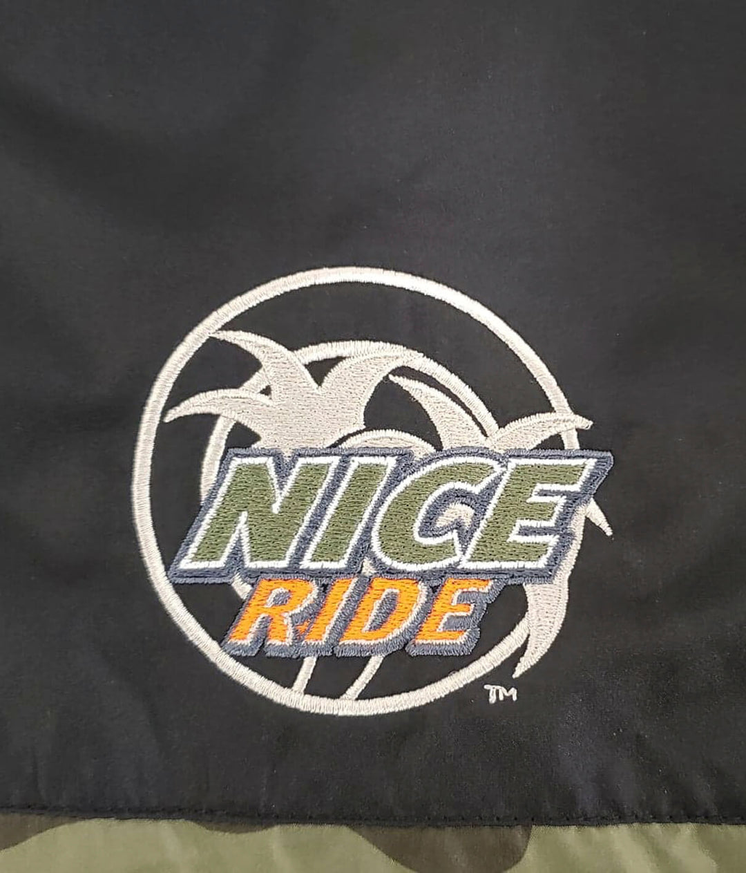 Embroidered NICERIDE logo on the Lightweight Windbreaker jacket, showcasing the brand&