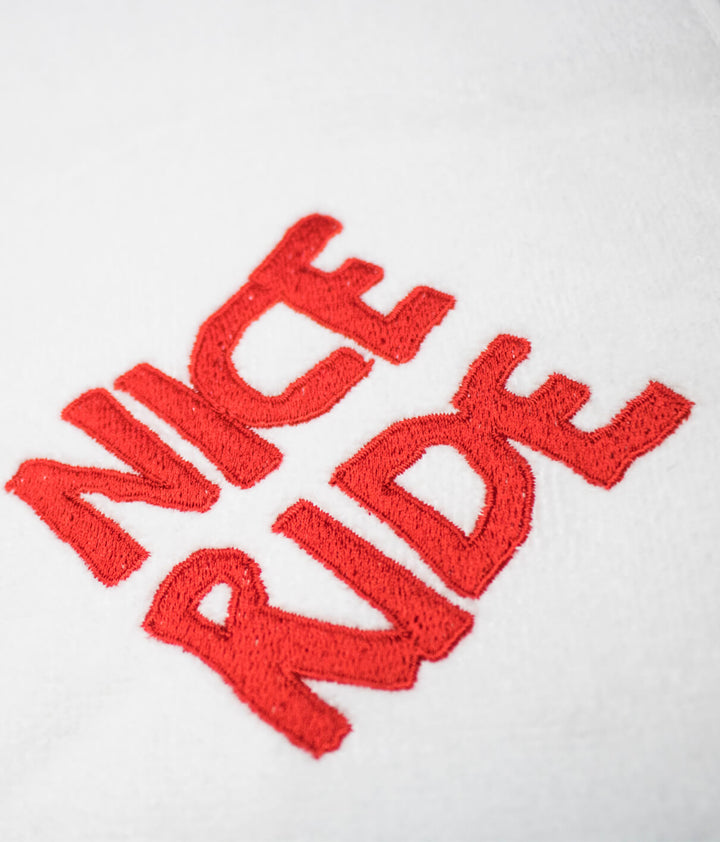 CR Ride golf towel with vibrant red embroidery on soft cotton fabric featuring the words NICE RIDE.