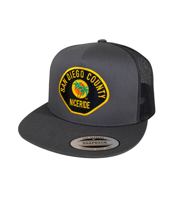 The Badge trucker hat with San Diego County design, classic snapback style, featuring NICERIDE logo.