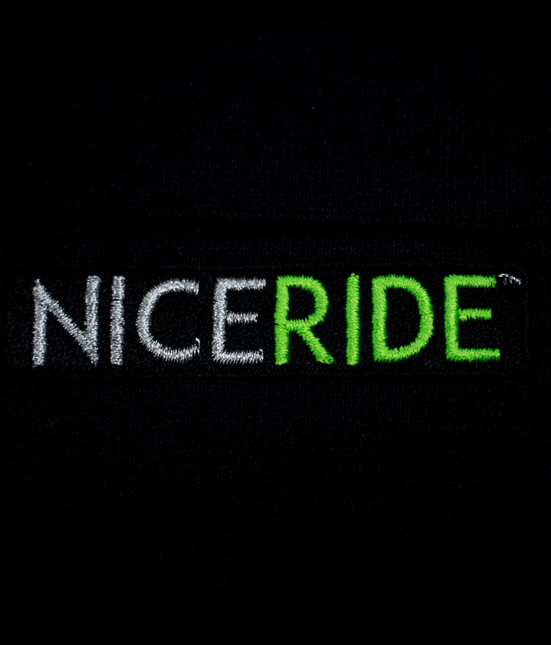 NICERIDE logo embroidered in white and green on a black background from a hoodie.