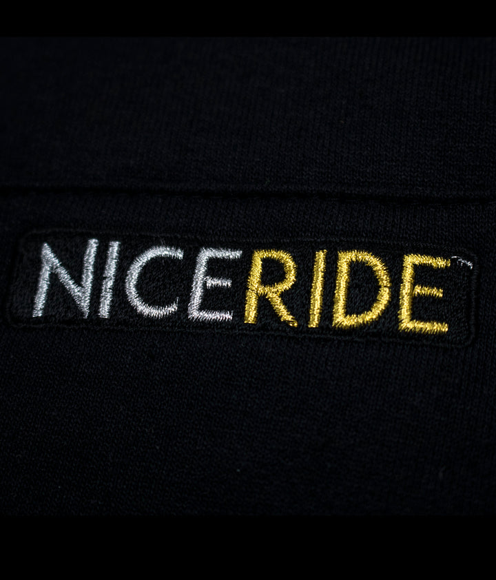Close-up of NICERIDE logo in embroidered detail on the black pullover hoodie.