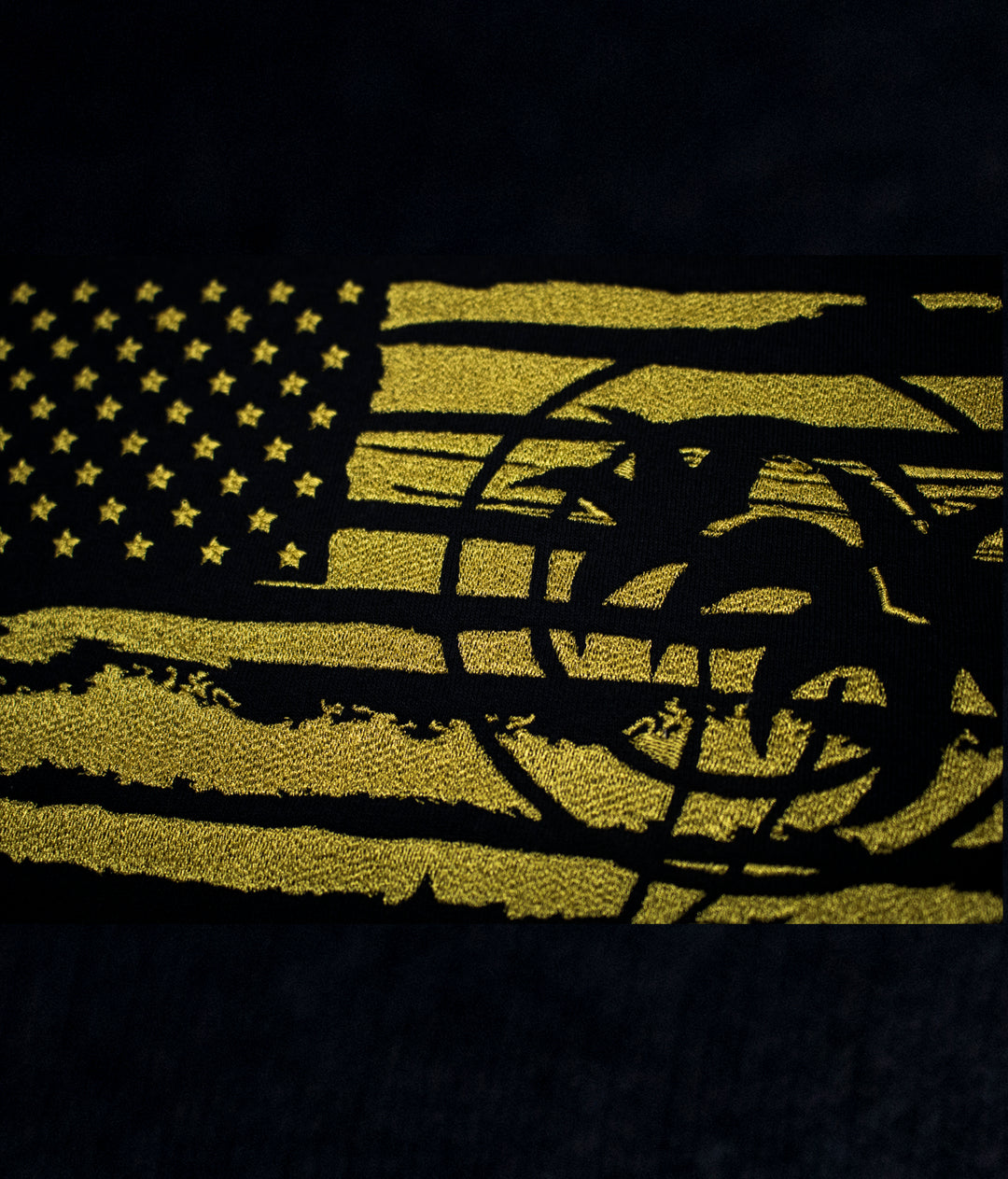 Embroidered American flag design in yellow on black fabric, featured on the Strong Faded hoodie.