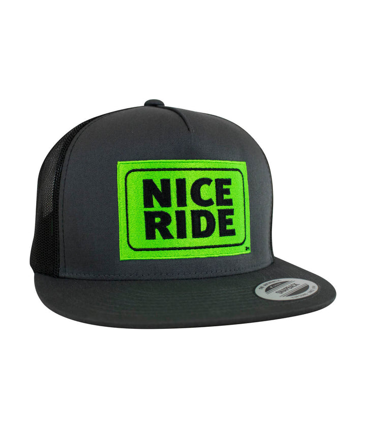 NICERIDE Shield Trucker Hat featuring vibrant green embroidery on a classic black snapback hat.