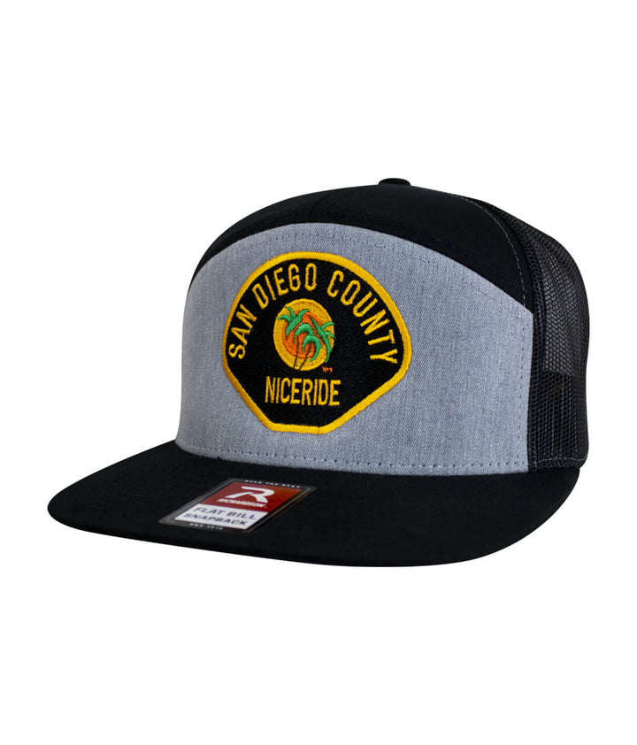 The Badge 7 Panel Trucker Hat, embroidered design, adjustable baseball cap from NICERIDE.