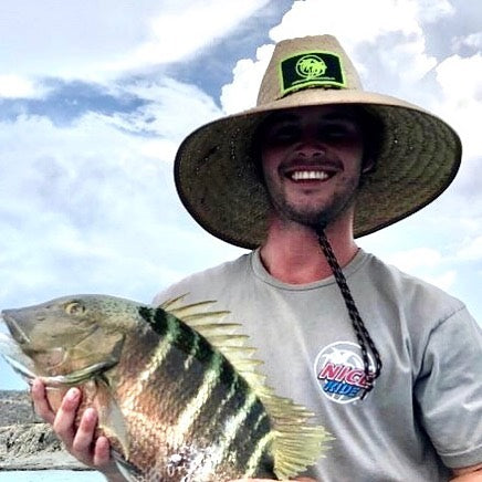 Unisex straw hat worn by a fisherman holding a large fish, showing NICERIDE&