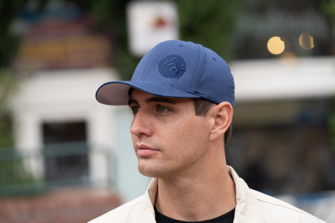 Man wearing a blue "Tone" Classic Flexfit Hat featuring NICERIDE&