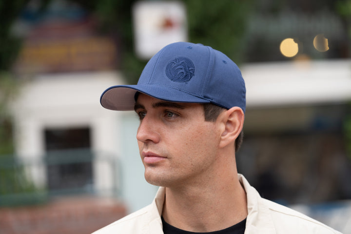 Man wearing a blue "Tone" Classic Flexfit Hat featuring NICERIDE&