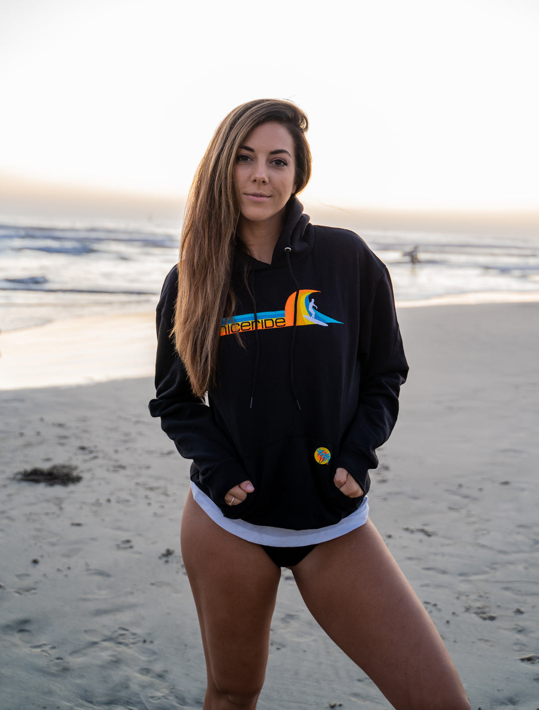 Black unisex pullover hoodie featuring Tasty Waves design, perfect for stylish comfort at the beach.