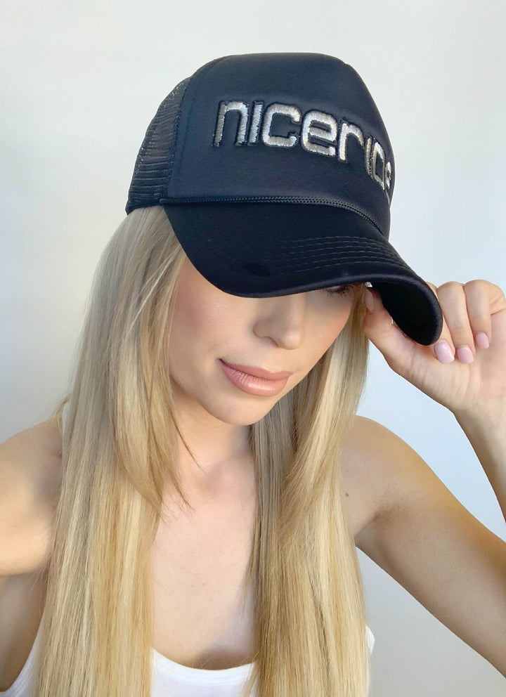 woman wearing the Bold Tower Black Foam Trucker Hat featuring the NICERIDE logo
