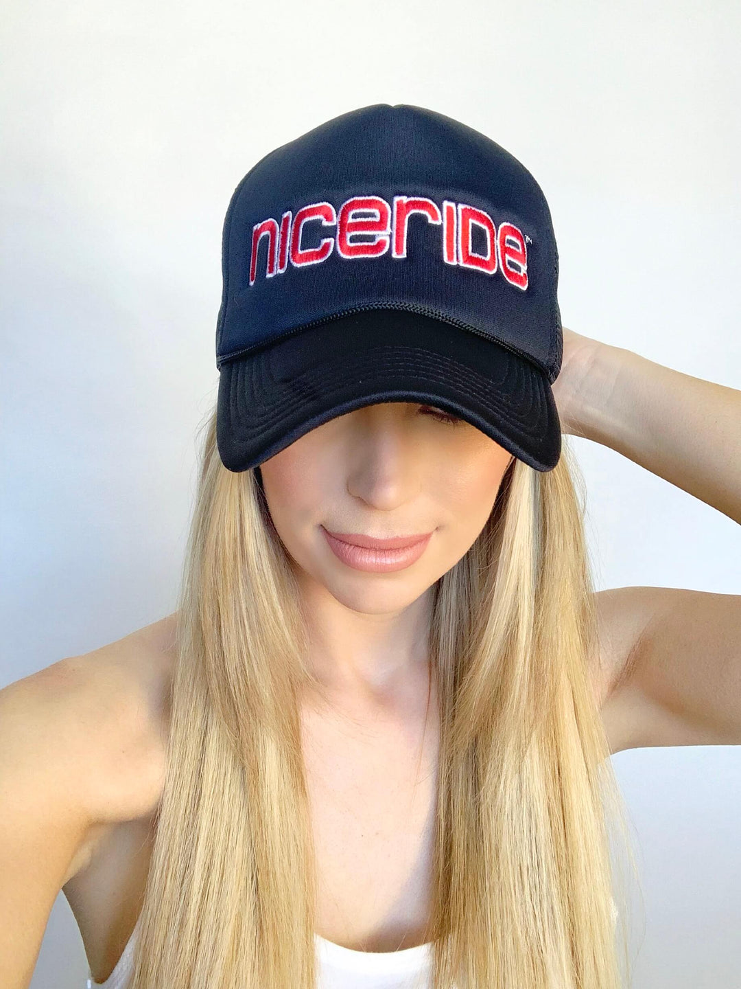 Bold Tower Black Foam Trucker Hat featuring NICERIDE logo worn by a model with long blonde hair.