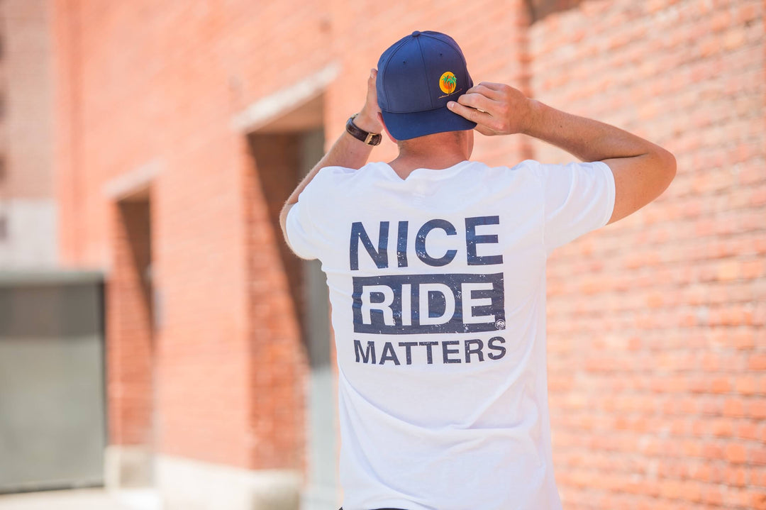 Man wearing Niceride Matters shirt outdoors, showcasing blue and white Hanes men&