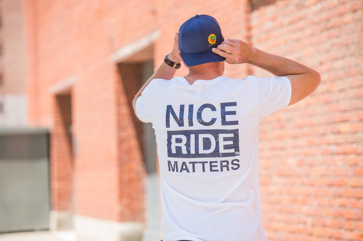 Man wearing Niceride Matters shirt outdoors, showcasing blue and white Hanes men&