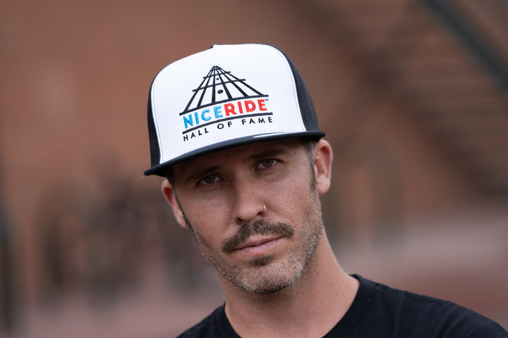 Man wearing a NICERIDE "Strings" Trucker Baseball Cap showing front design, perfect hat for outdoor activities.
