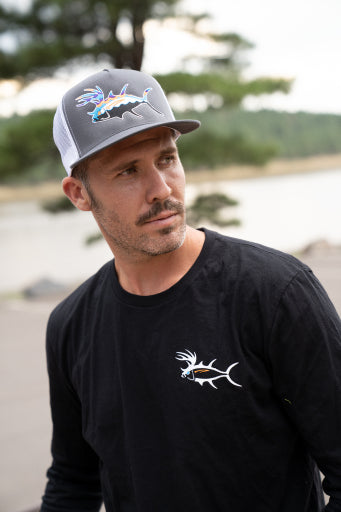 Man wearing a Buck-Eye Explorer unisex snapback trucker hat by NICERIDE outdoors near a body of water.