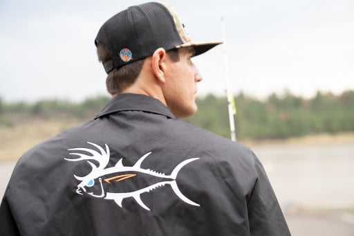 Man wearing a black jacket featuring a unique fish design on the back, ideal for fishing adventures.